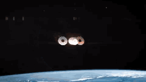a space ship is flying over the earth in the night sky