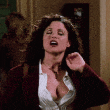a woman in a white shirt and a red jacket is making a funny face