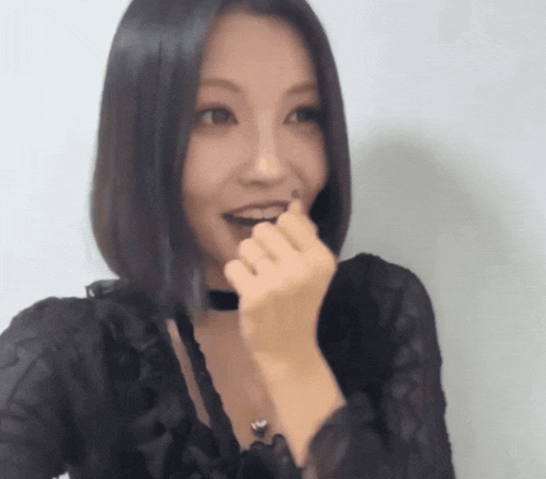 a woman wearing a choker and a black top is making a funny face