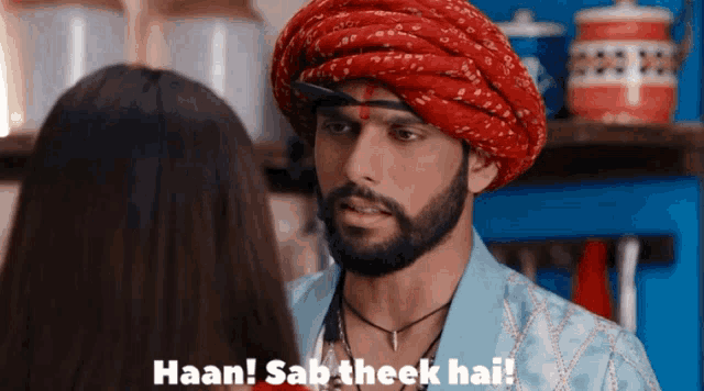 a man wearing a turban talks to a woman and says " haan sab theek hai "