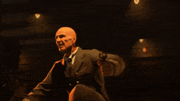 a man in a leather jacket is pointing his finger at the camera