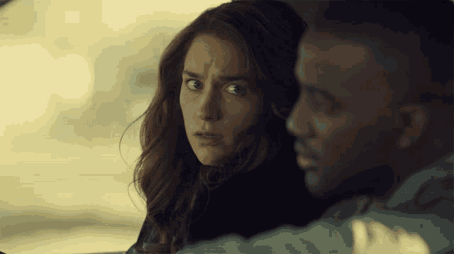 a man and a woman are looking at each other