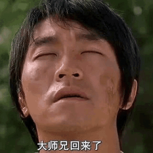 a close up of a man 's face with his eyes closed and chinese writing on it .