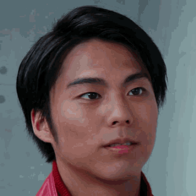 a close up of a man 's face with a red jacket
