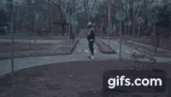 a man is riding a segway down a street in a park .