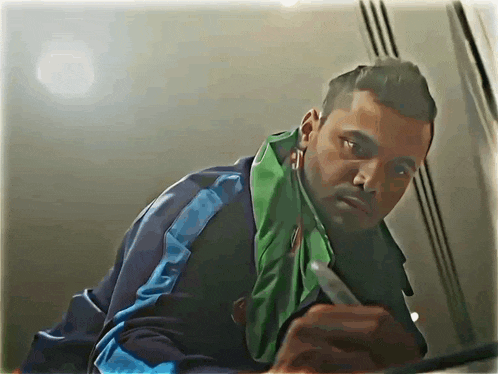 a man with a green scarf around his neck and a pen in his hand