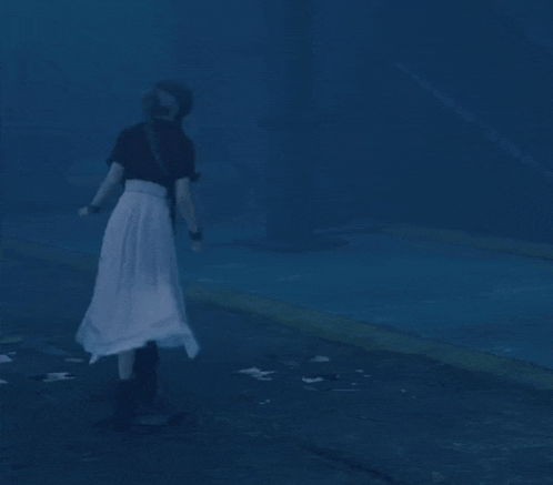 a blurry picture of a woman in a white skirt walking in the dark