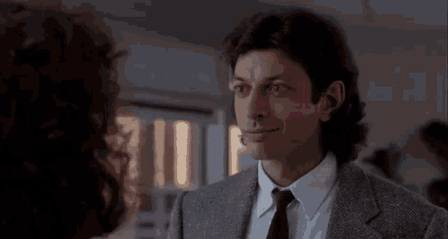 a man in a suit and tie talks to a woman with the words cheeseburger written in pink