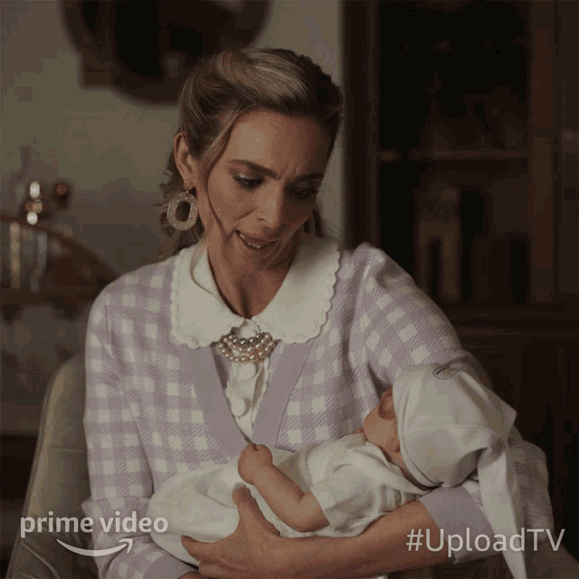 a woman is holding a baby in her arms with a prime video logo in the corner