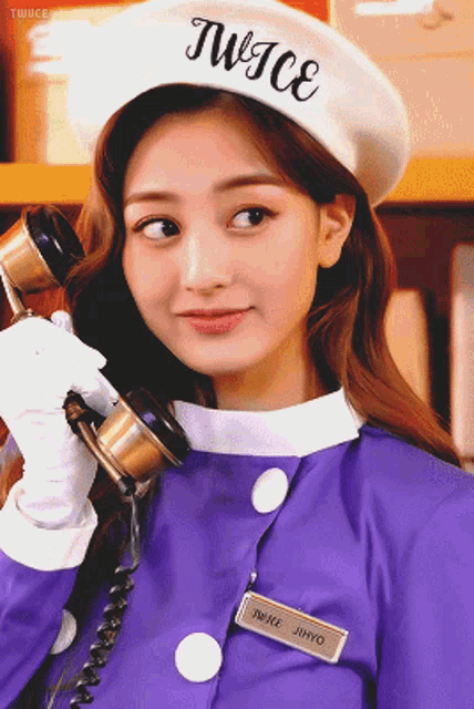 a woman wearing a purple uniform and a white hat with the word twice written on it