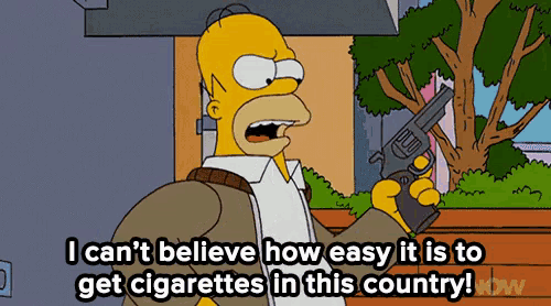 homer simpson holding a gun and saying i can 't believe how easy it is to get cigarettes in this country !