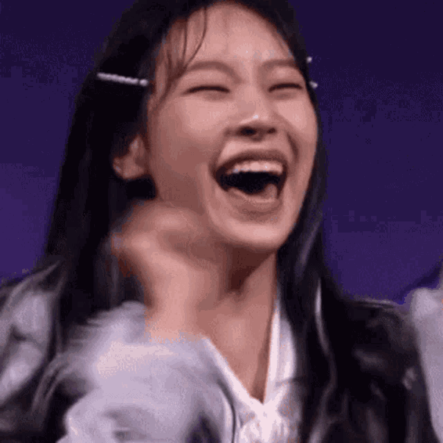 a close up of a woman laughing with her mouth open and her eyes closed .