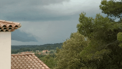 a roof with a tile roof and a cloudy sky behind it
