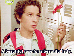 a boy is holding a red flower with the words a beautiful rose for a beautiful lady