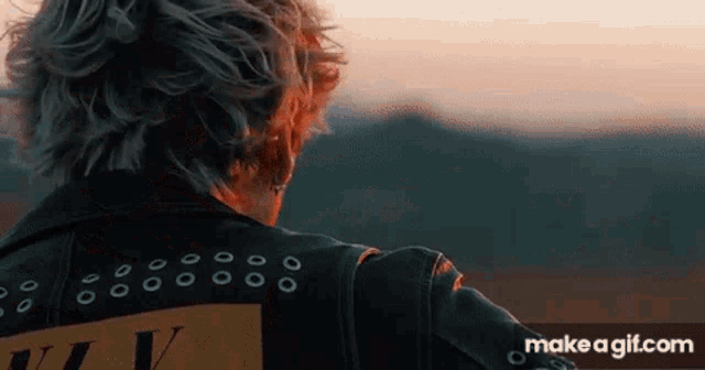 a person wearing a leather jacket with the word v on the back