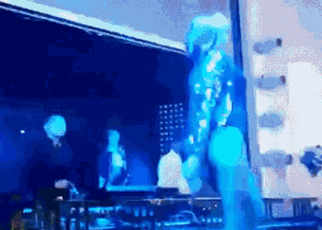 a man in a blue suit is standing on a stage in front of a microphone