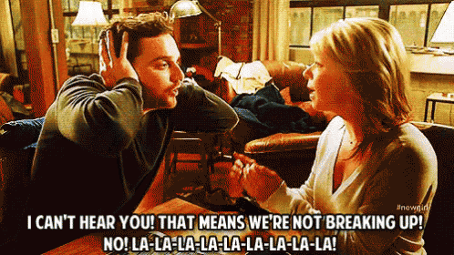 a man and a woman are sitting at a table and the woman is saying i can 't hear you