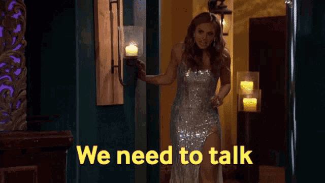 a woman in a silver dress is walking down a hallway and says we need to talk .