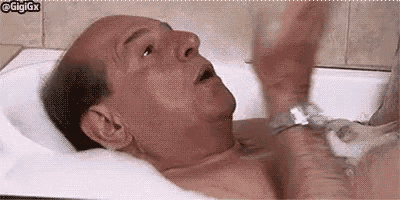 an older man is taking a bath in a bathtub with foam .