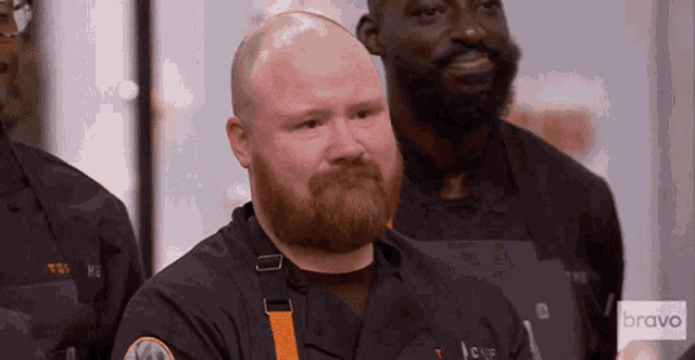 a man with a red beard is wearing an apron that says bravo