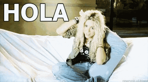 a woman is sitting on a bed with the word hola above her head