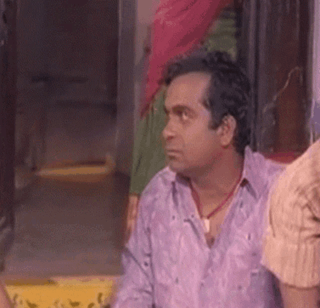 a man in a purple shirt is sitting next to a woman in a green shirt .