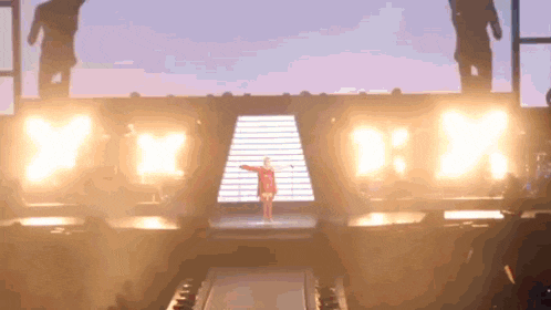 a woman in a red top is standing on a stage in front of a sign that says ' yeah '