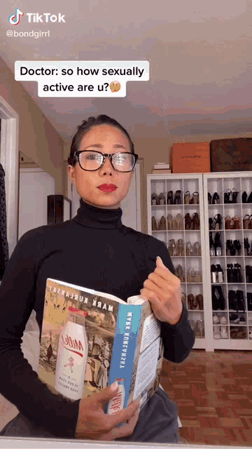 a woman wearing glasses holds a book that says " how sexually active are u " on it