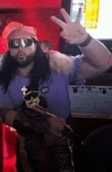 a man with long hair and a beard is wearing sunglasses and giving a peace sign