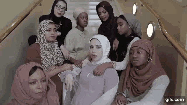 a group of women wearing hijabs are posing for a picture on the stairs
