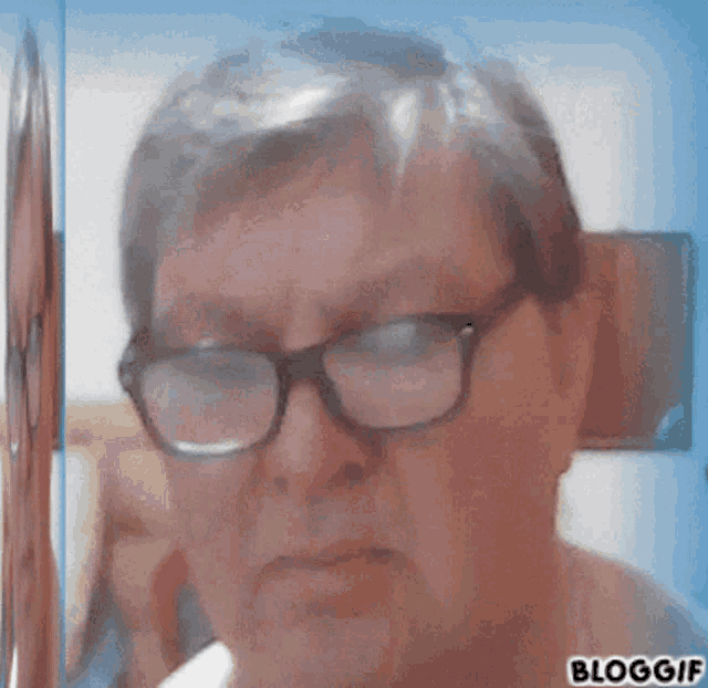 a close up of a man wearing glasses with the words bloggif written below him