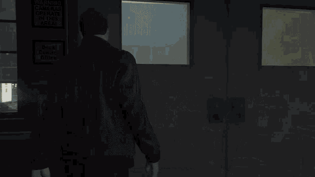 a man standing in a dark room with a sign on the wall that says ' emergency '