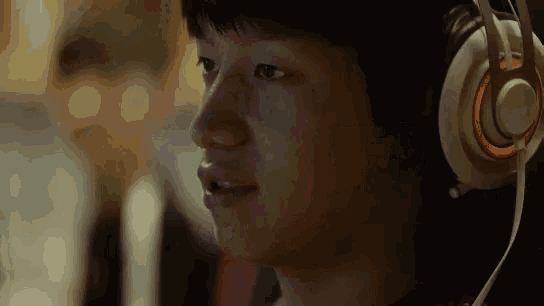 a close up of a person wearing headphones with an orange light