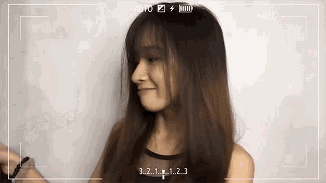 a woman 's face is being recorded with the numbers 3 2 1 and 1 visible