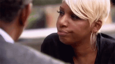 a woman wearing hoop earrings is looking at a man in a car .