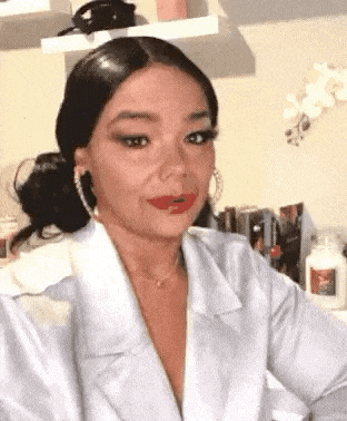 a woman wearing a white shirt and red lipstick is making a funny face .