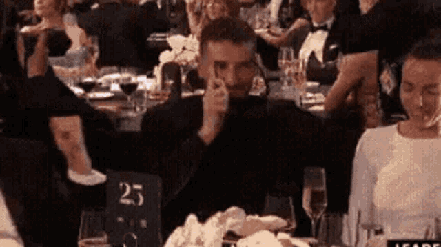 a man is sitting at a table with a table number 25