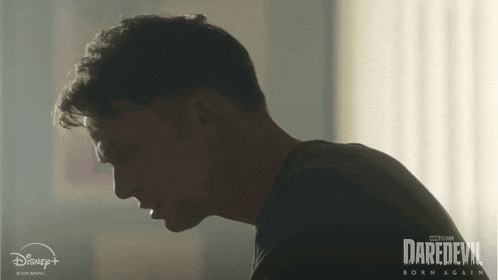 a poster for daredevil born again shows a man in a dark room