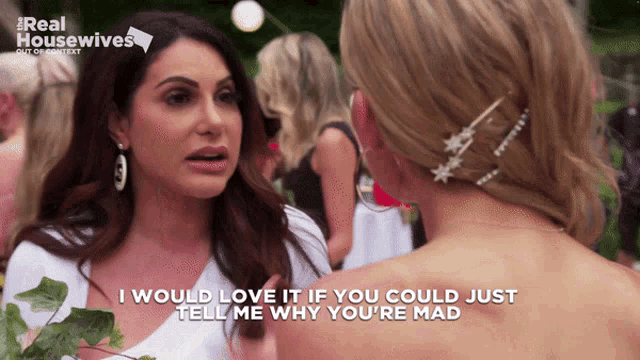 two women are talking in front of a real housewives logo