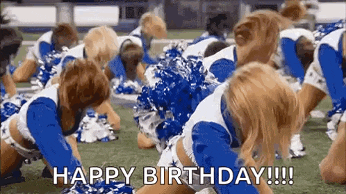 a group of cheerleaders are kneeling down on a football field and saying happy birthday .