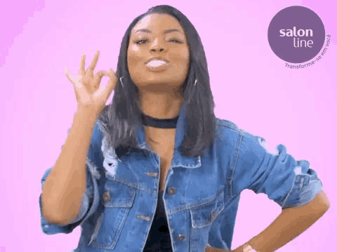 a woman in a denim jacket is giving the ok sign
