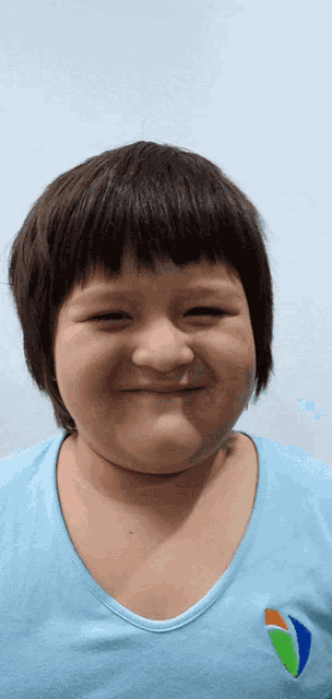 a young girl wearing a blue shirt with a sailboat on it