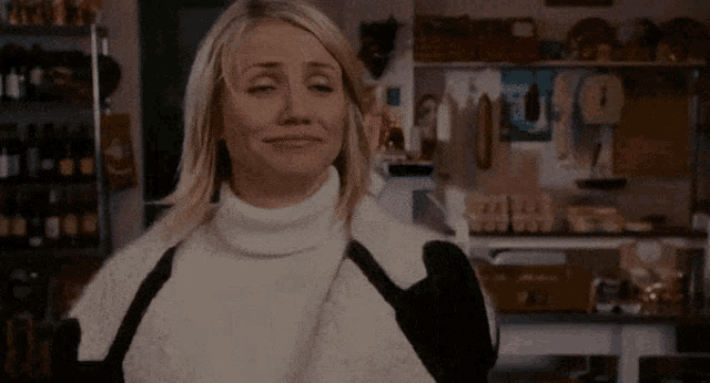a woman in a sweater says oh yeah in a kitchen
