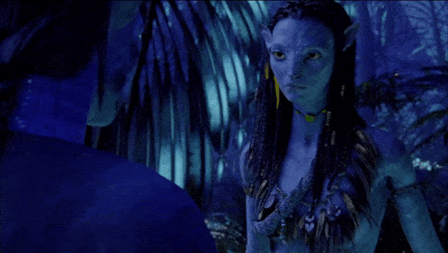 a woman with blue hair is standing next to a man in a dark room