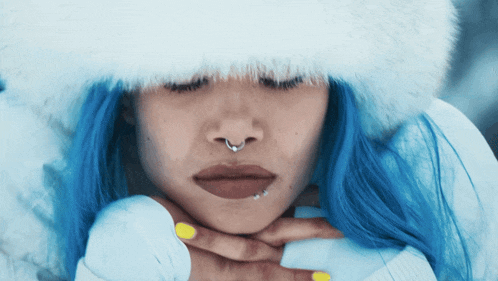 a woman with blue hair is wearing a white fur hat and a nose ring