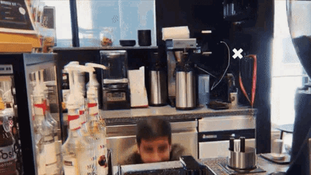 a man behind a counter in a kitchen with a sign that says ' bubble tea ' on it