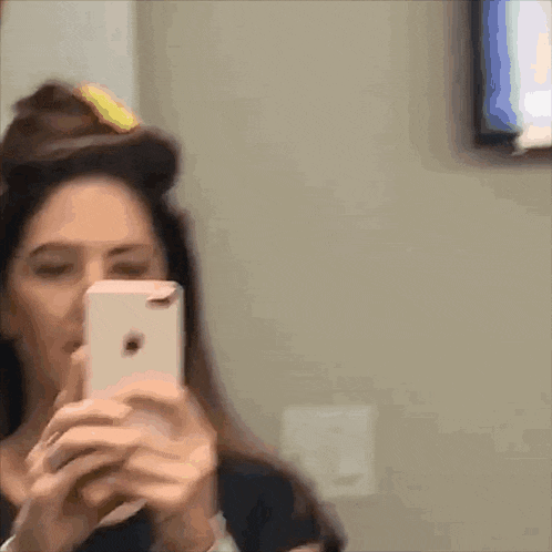 a woman is taking a picture of herself with her cell phone