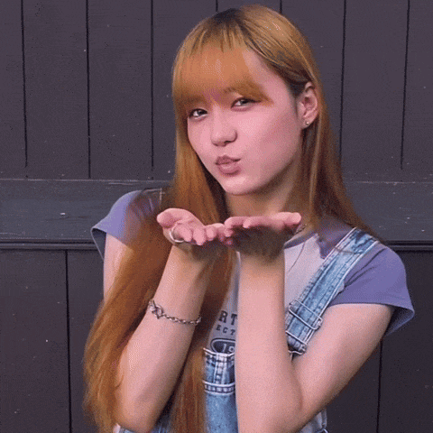 a woman blowing a kiss wearing a purple shirt that says rt