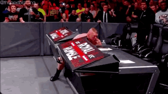 a wrestler is laying on a table with a sign that says royal rumble
