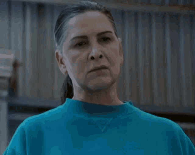 a close up of a woman wearing a blue sweatshirt .